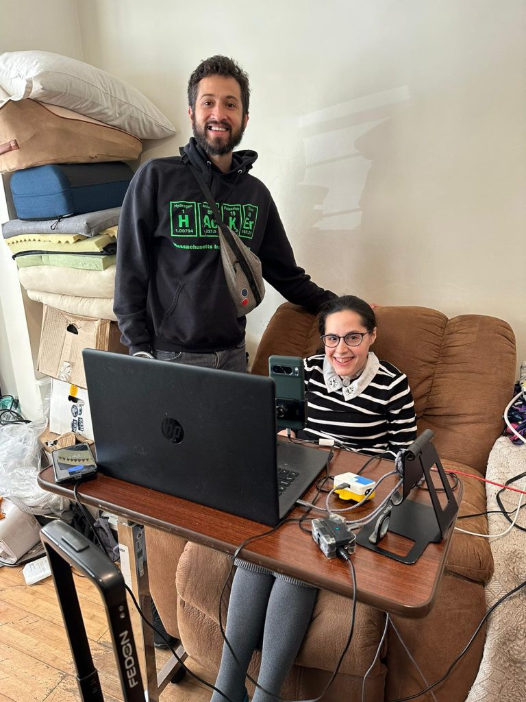 Esther sitting on a couch, getting fitted for the Mouthpad with Tomas Vega.