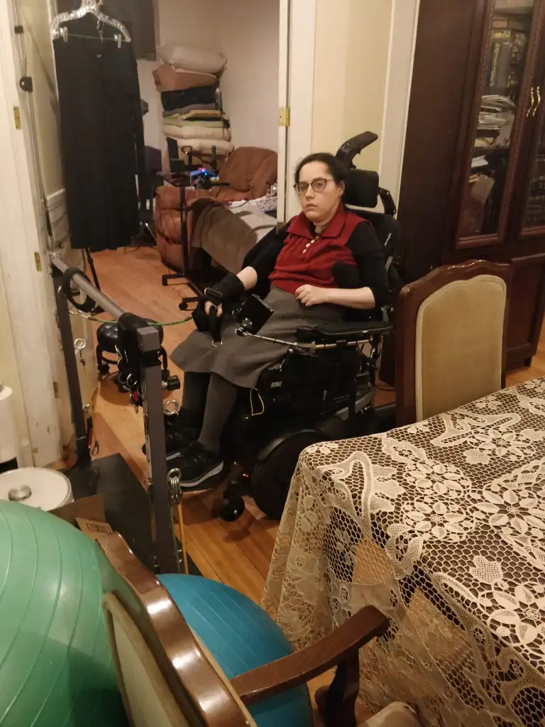 Me doing a physio exercise at home in my wheelchair. It's an arm exercise where I use a resistance band attached to a horizontal pole in front of me.